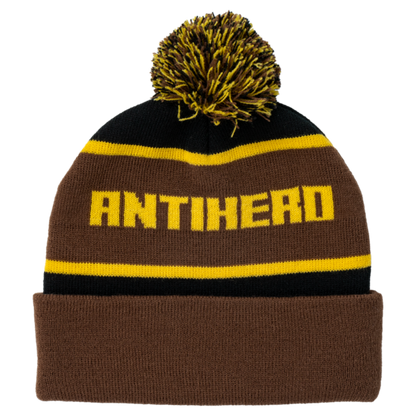 Brown and black beanie with yellow pom-pom and 'ANTIHERO' text on a white background