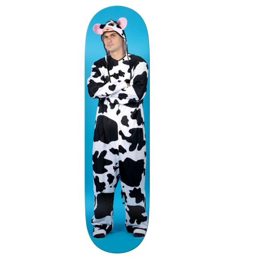 Person wearing a cow print onesie standing on a blue skateboard deck.