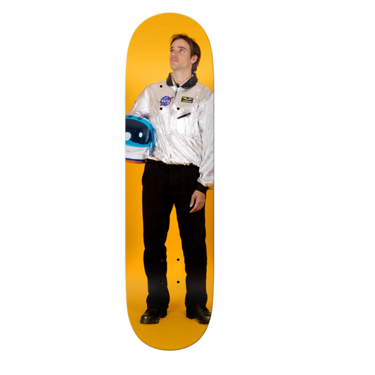 Skateboard deck with a person wearing a white jacket and black pants on a yellow background